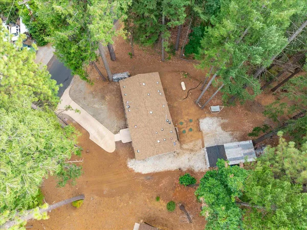 an aerial view of a house with a yard and trees
