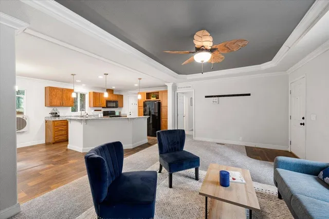 a living room with furniture kitchen view and a chandelier