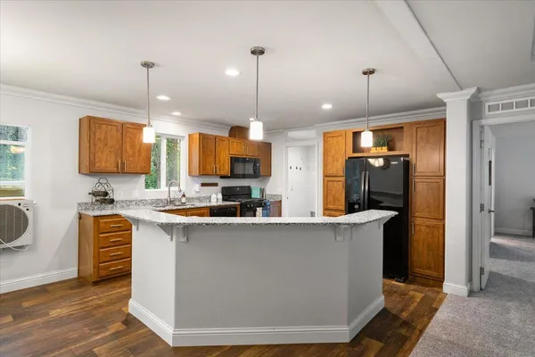a kitchen with stainless steel appliances a refrigerator a sink a stove a kitchen island and cabinets