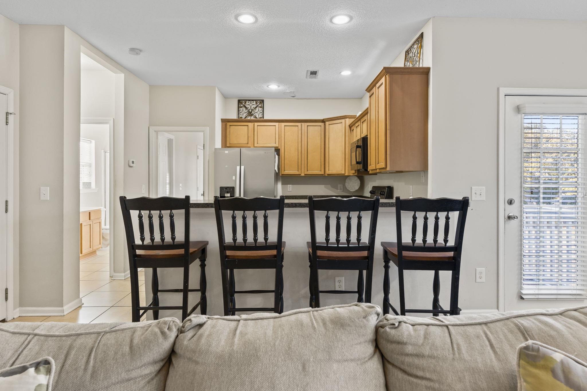 311 B 3rd Avenue North Surfside Beach, SC 29575 - Photo 14 of 39 Kitchen with a breakfast bar area, freestanding refrigerator, recessed lighting, a peninsula, and dark countertops