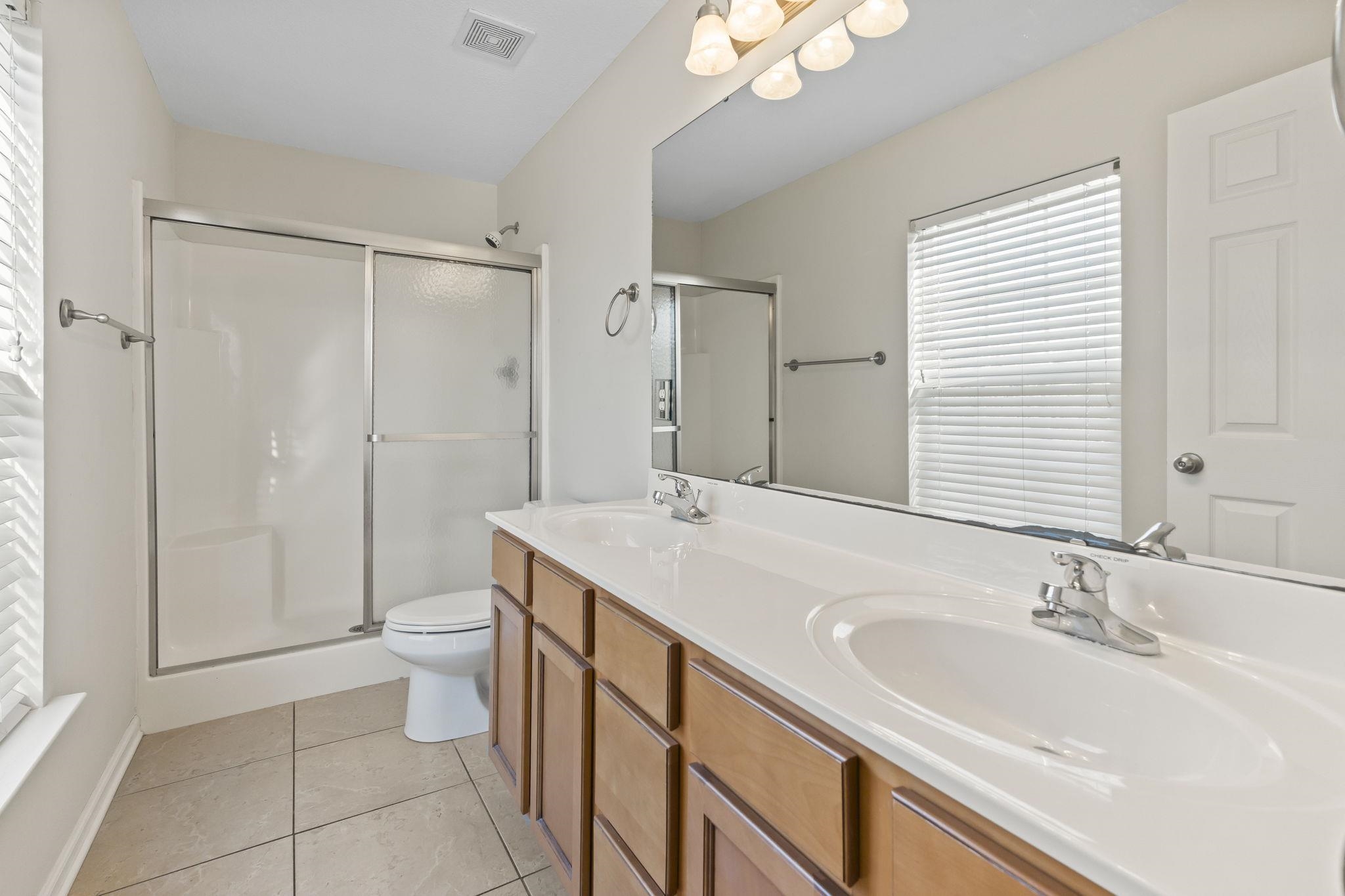311 B 3rd Avenue North Surfside Beach, SC 29575 - Photo 24 of 39 Bathroom with double vanity, plenty of natural light, a shower stall, and light tile patterned floors