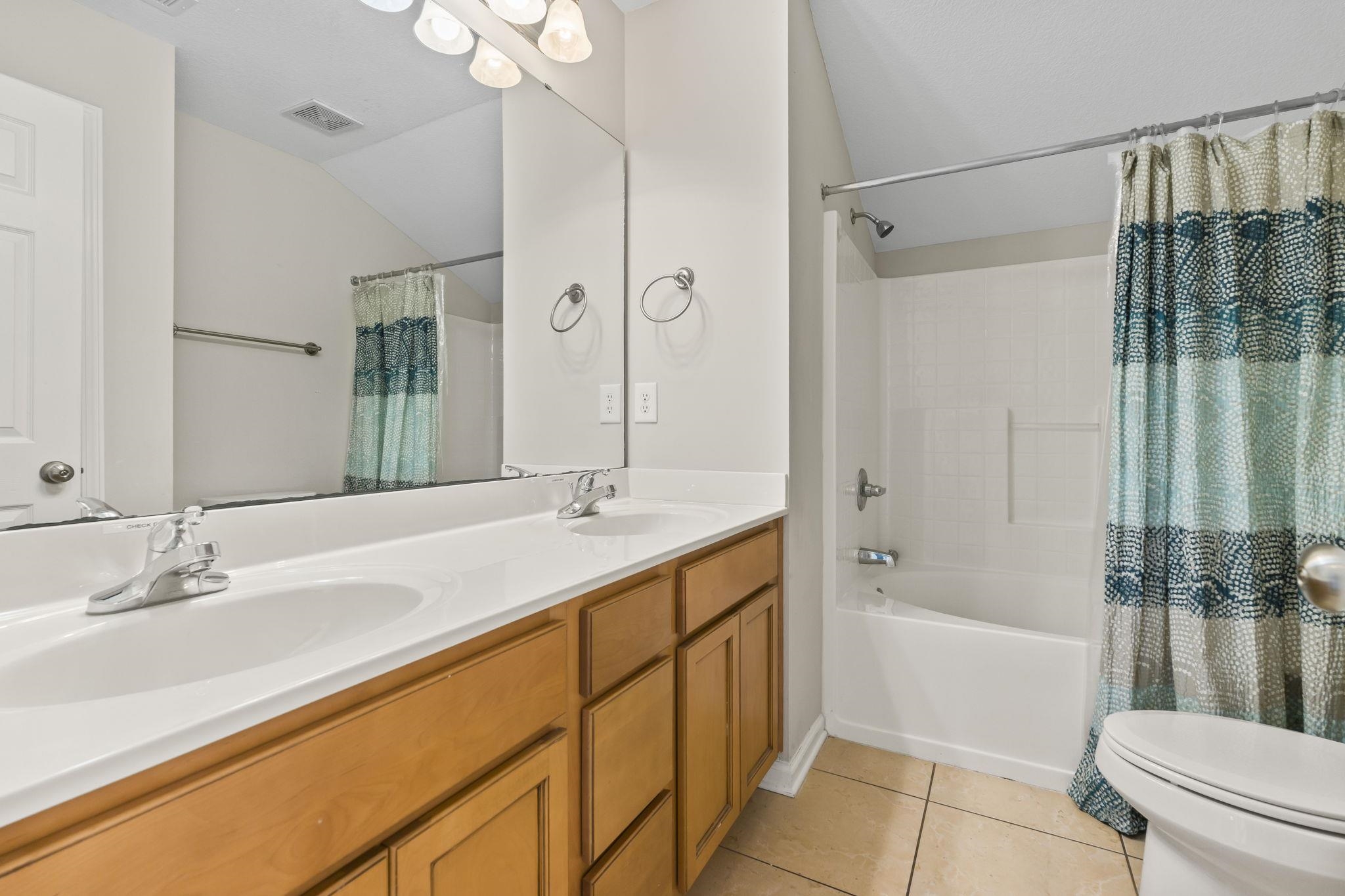 311 B 3rd Avenue North Surfside Beach, SC 29575 - Photo 30 of 39 Full bath with double vanity, shower / bathtub combination with curtain, and light tile patterned floors