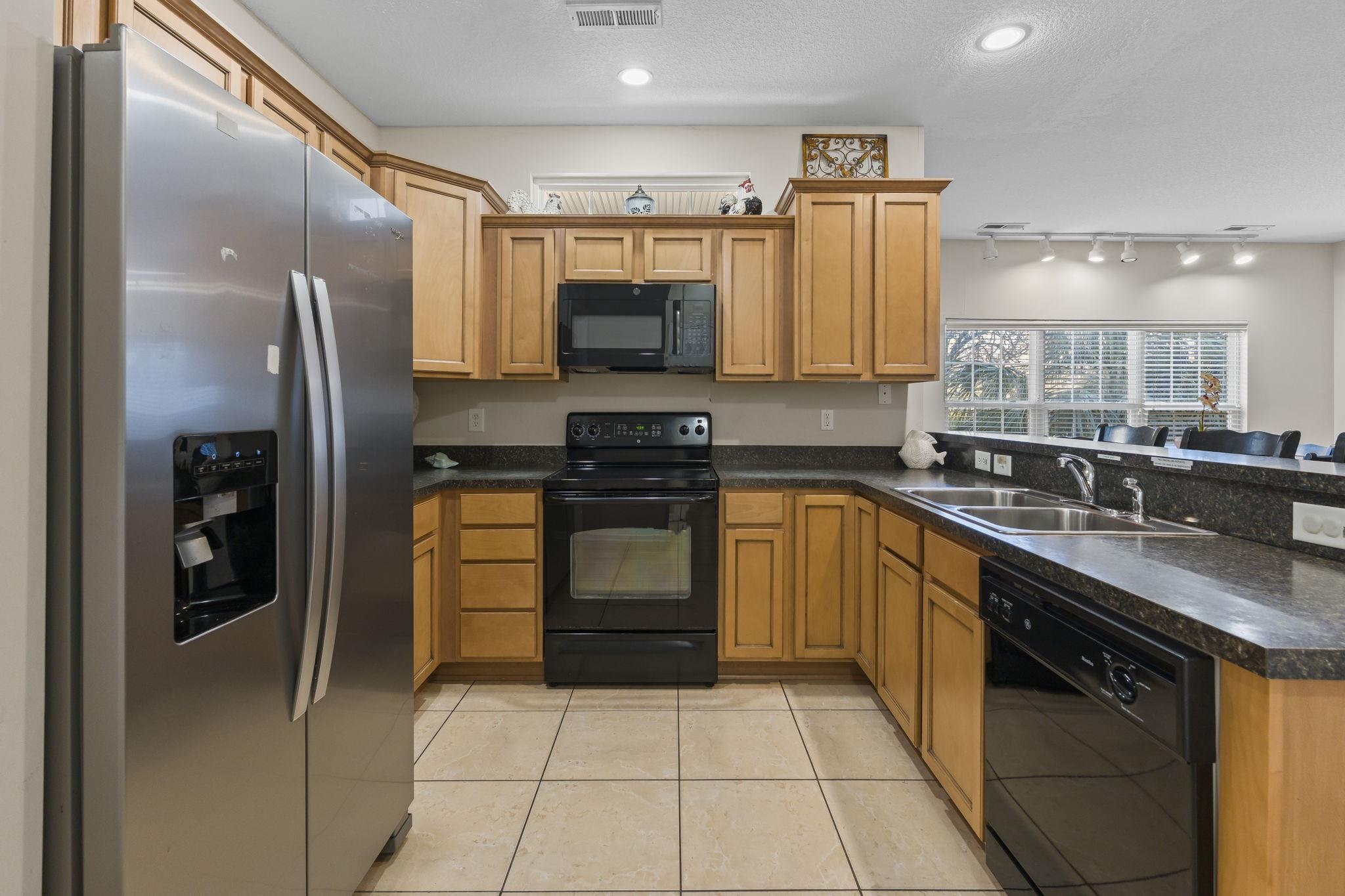 311 B 3rd Avenue North Surfside Beach, SC 29575 - Photo 6 of 39 Kitchen with black appliances, dark countertops, a textured ceiling, a peninsula, and brown cabinets
