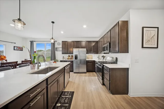 a kitchen with counter top space a sink appliances and cabinets