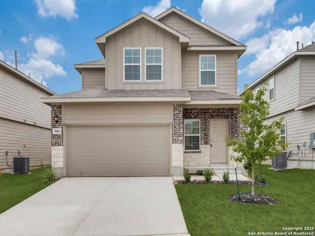 a front view of a house with a garden and yard