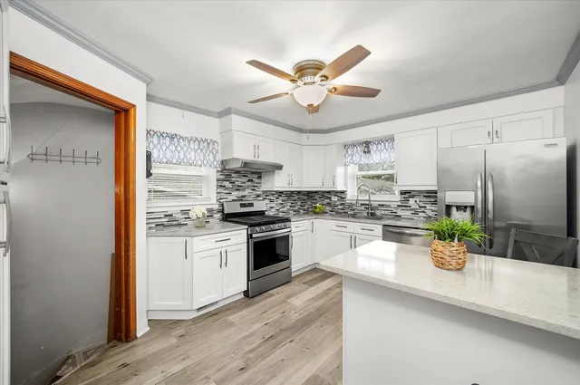 a kitchen with white cabinets and stainless steel appliances