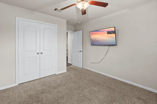 en empty room with window and ceiling fan