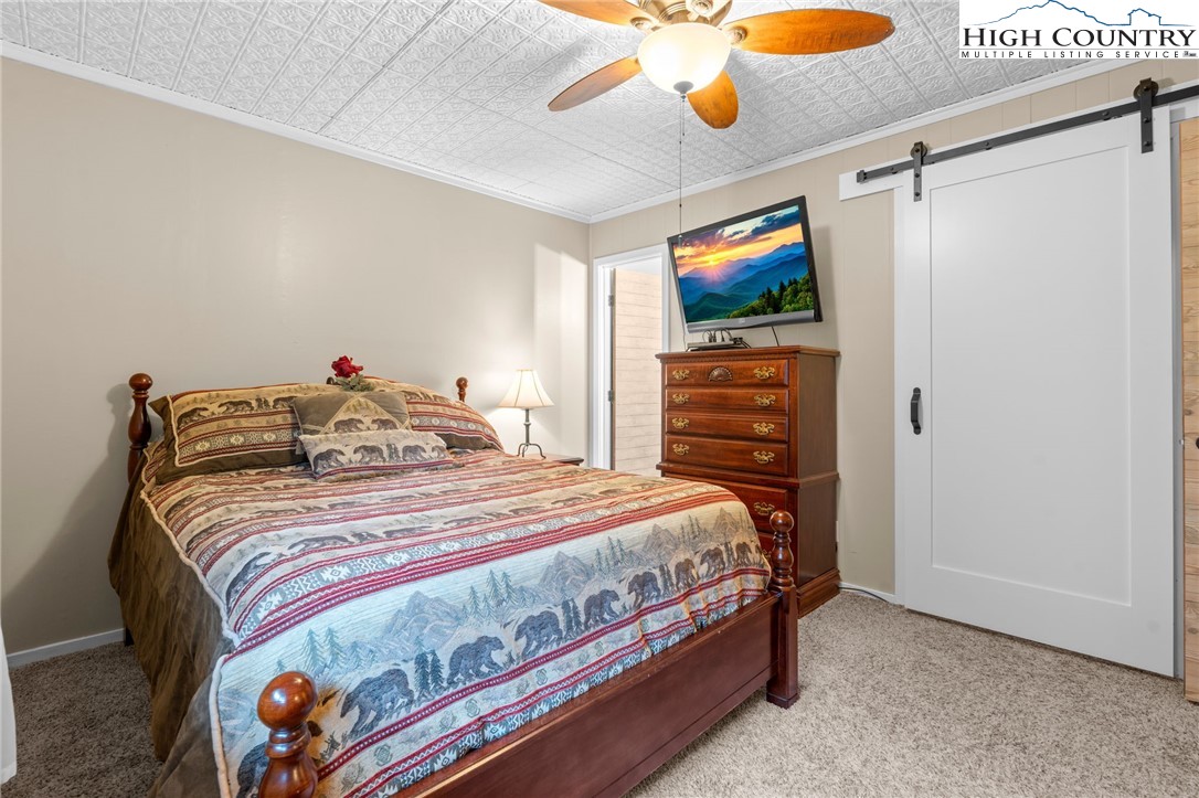 301 Pinnacle Inn Road, Unit 3219 Beech Mountain, NC 28604 - Photo 13 of 30 a bedroom with a bed and a flat screen tv