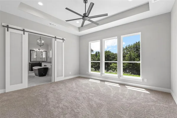 a view of a room with a large window and a ceiling fan