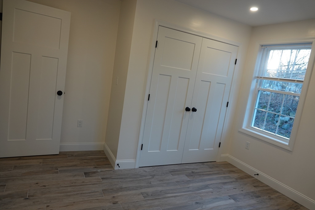 6 Pondover Road, Unit ADU Billerica, MA 01821 - Photo 9 of 20 a view of an empty room with wooden floor and a window