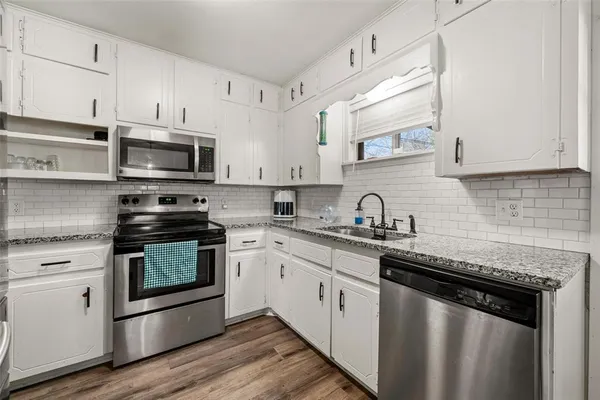 a kitchen with stainless steel appliances granite countertop a sink stove a microwave and cabinets