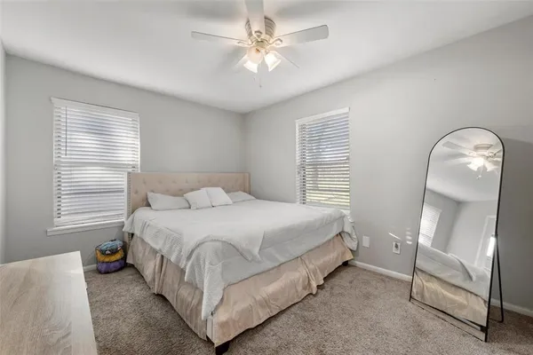 a bedroom with a bed a mirror and a chandelier
