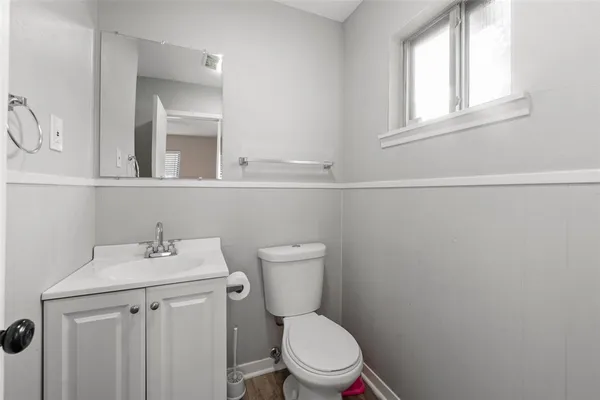 a bathroom with a toilet sink and mirror