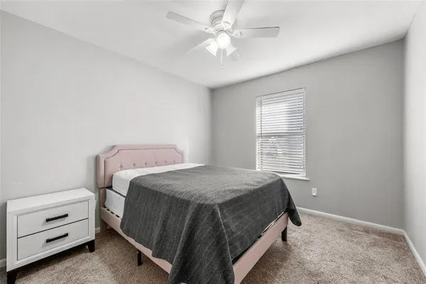 a bedroom with a bed and a ceiling fan