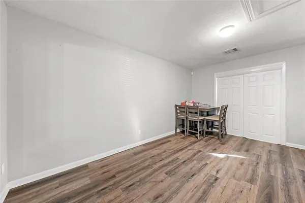 an empty room with wooden floor and piano