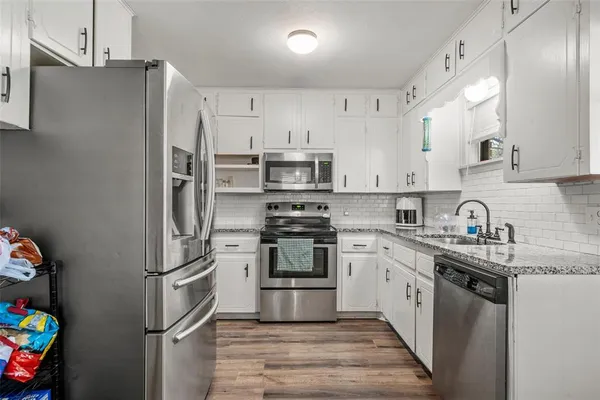 a kitchen with stainless steel appliances granite countertop a refrigerator sink and stove