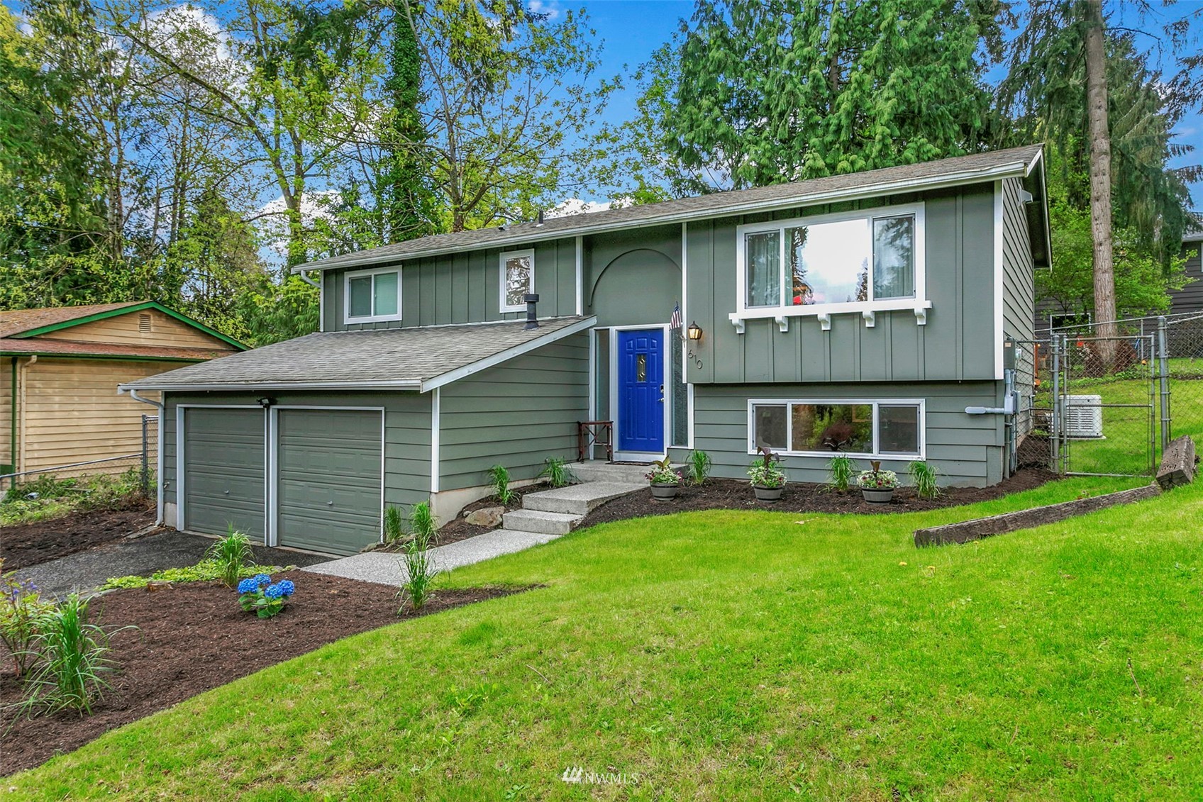 a front view of a house with a garden and yard