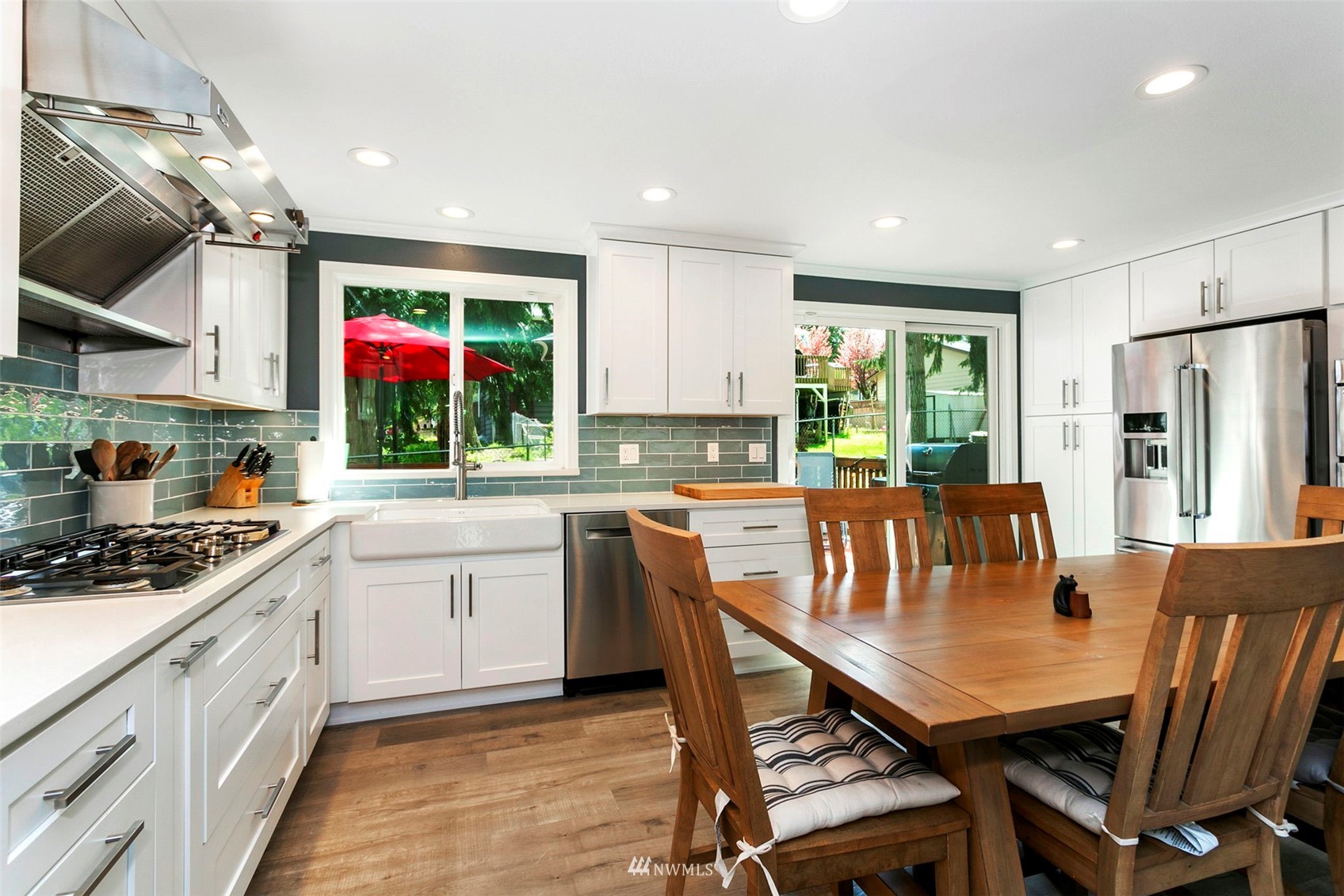 610 219th Place Southwest Bothell, WA 98021 - Photo 5 of 25 a kitchen with stainless steel appliances granite countertop a stove a refrigerator a kitchen island with chairs and wooden floor