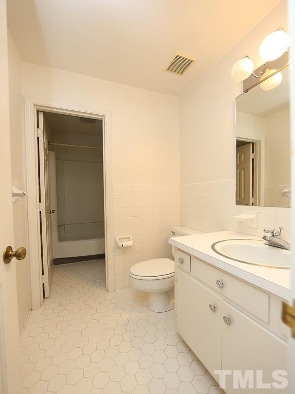 2816 Wycliff Road Raleigh, NC 27607 - Photo 7 of 12 a bathroom with a toilet a sink and mirror