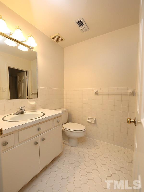 2816 Wycliff Road Raleigh, NC 27607 - Photo 9 of 12 a bathroom with a toilet a sink a mirror and vanity