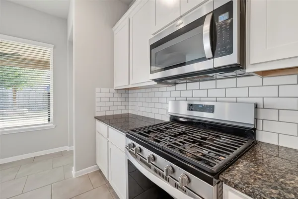 a stove top oven sitting inside of a kitchen