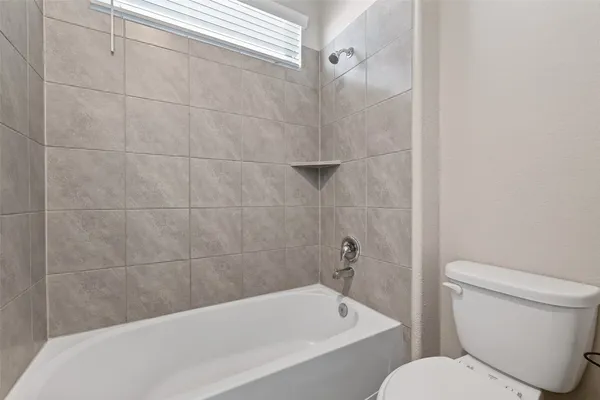 a white bath tub sitting next to a toilet