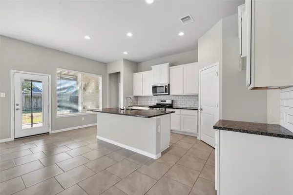 a large white kitchen with cabinets