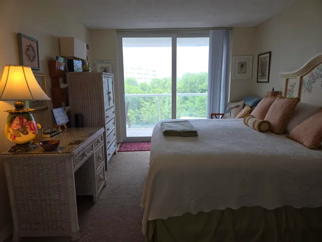 a bedroom with a bed and a flat tv screen next to a window