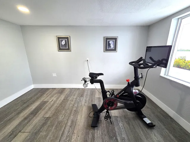 a room with gym equipment and wooden floor