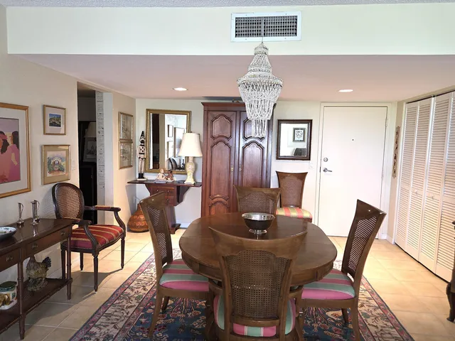 a view of a dining room with furniture a chandelier and wooden floor