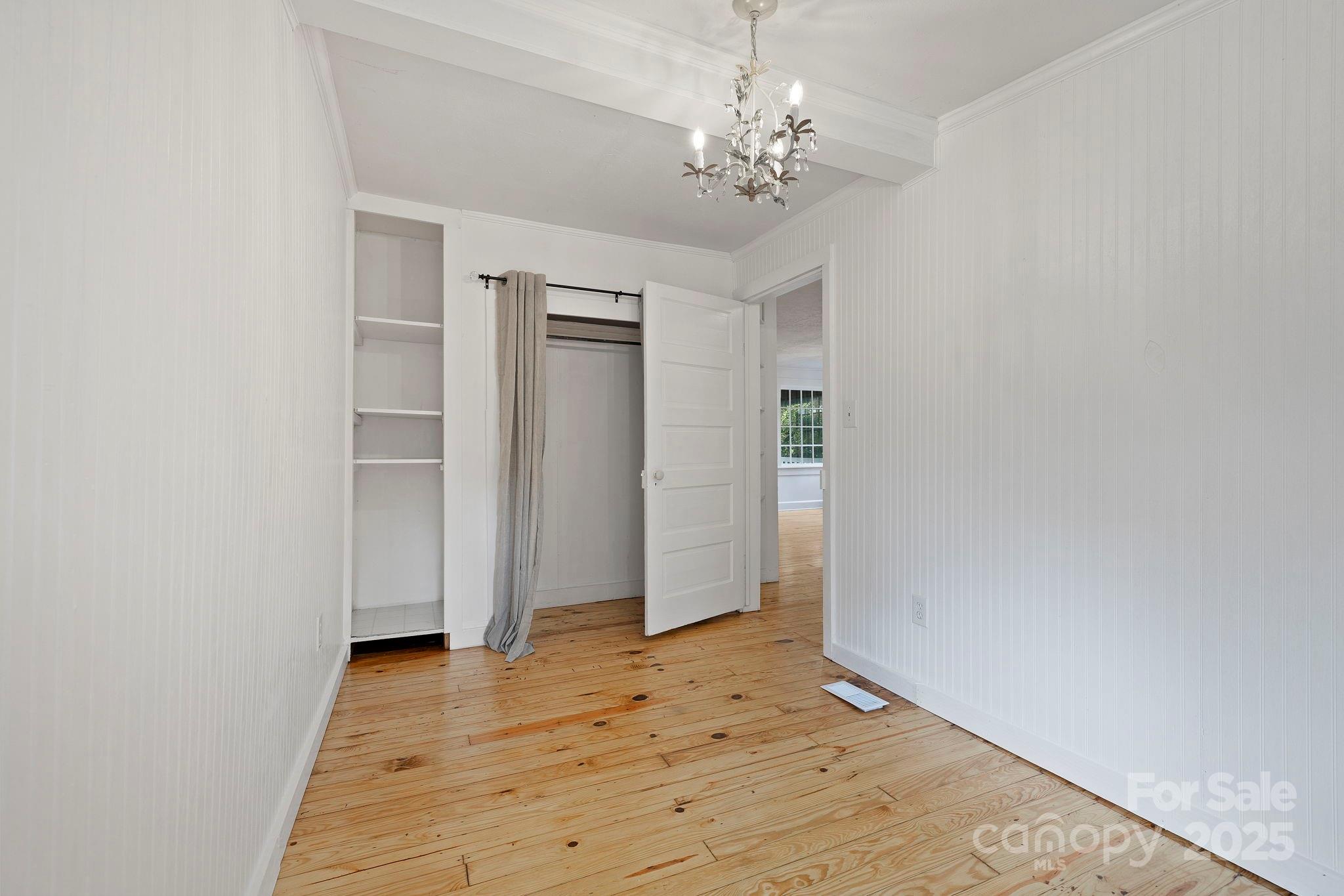 21 Maple Street Brevard, NC 28712 - Photo 24 of 29 an empty room with wooden floor chandelier fan and closet