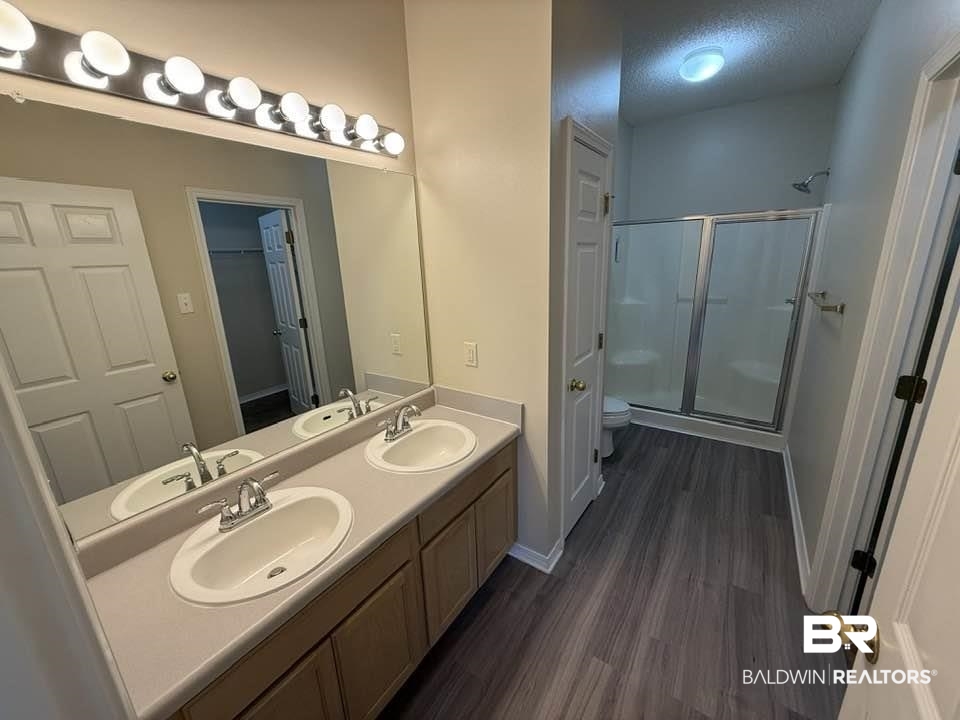 2651 South Juniper Street, Unit 401 Foley, AL 36535 - Photo 25 of 27 Full bath featuring a stall shower, a sink, and wood finished floors