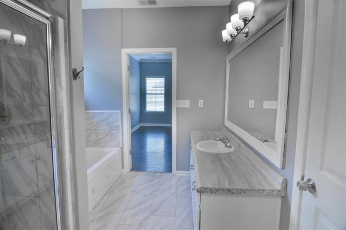 3430 Roxee Run Cove Bartlett, TN 38133 - Photo 12 of 32 a spacious bathroom with a granite countertop sink a toilet and shower