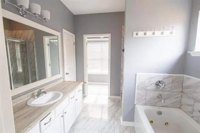 a bathroom with a tub sink and mirror