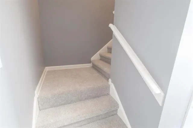 a view of staircase with wooden floor and white walls