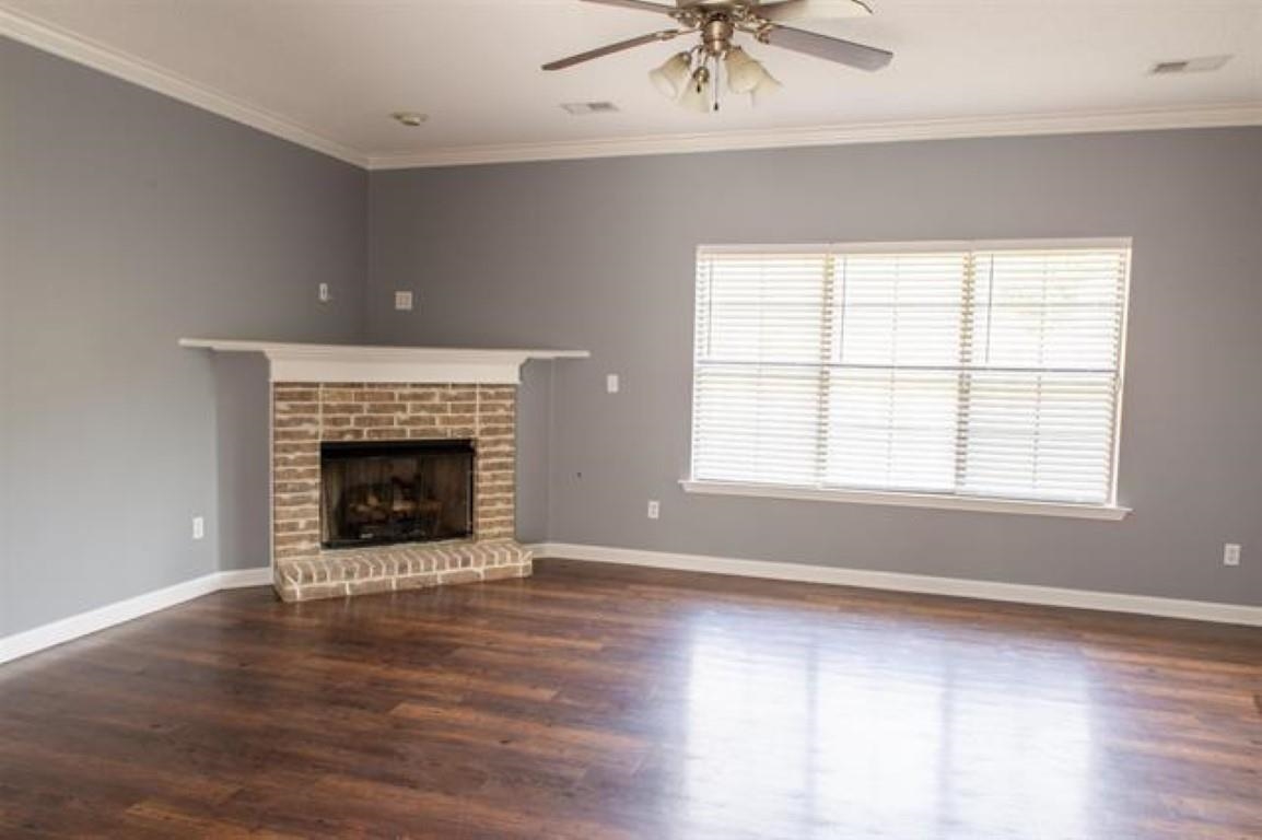 3430 Roxee Run Cove Bartlett, TN 38133 - Photo 4 of 32 an empty room with wooden floor a fireplace and windows