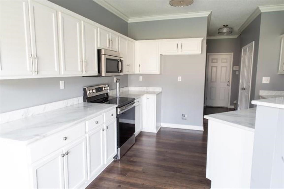 3430 Roxee Run Cove Bartlett, TN 38133 - Photo 5 of 32 a kitchen with stainless steel appliances a white refrigerator a stove top oven a sink and dishwasher with wooden floor
