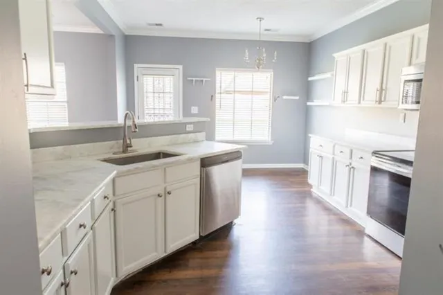 a kitchen with granite countertop a sink stove and cabinets