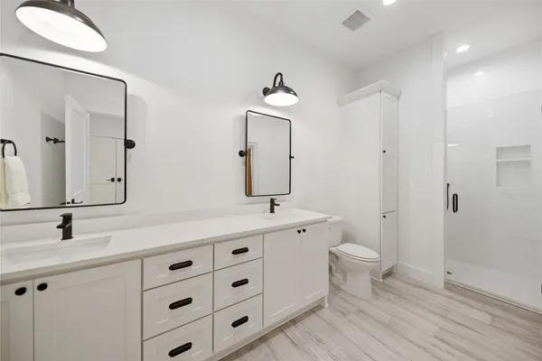 a bathroom with a sink a toilet and shower