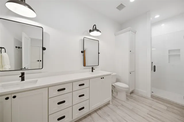 a bathroom with a sink a toilet and shower