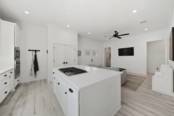 a kitchen that has a sink a stove and a wooden floor