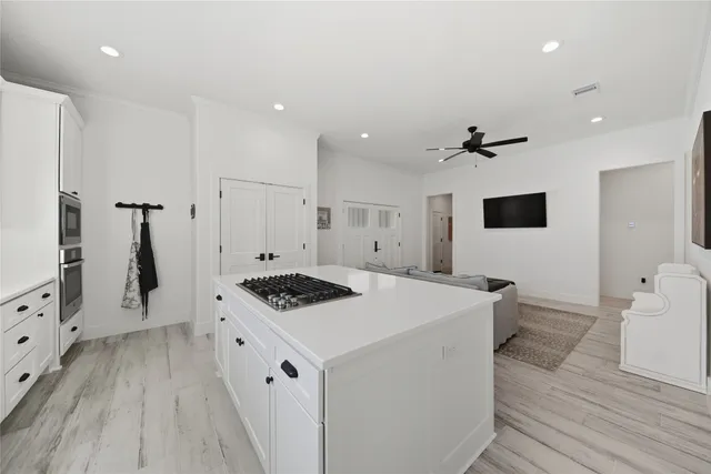 a kitchen that has a sink a stove and a wooden floor