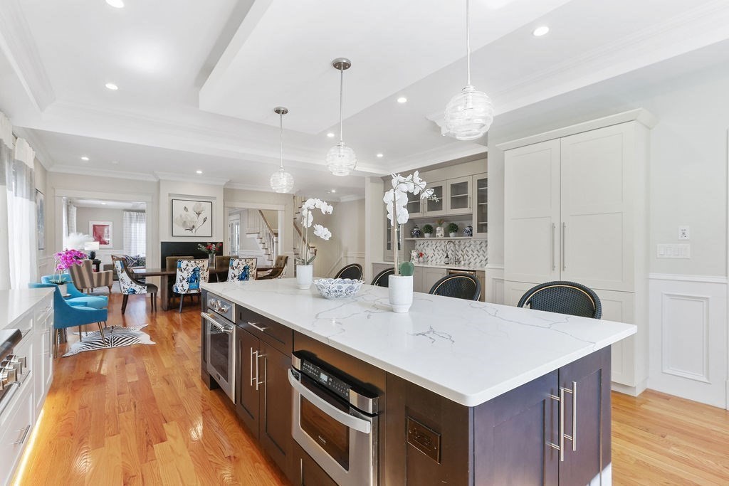 5 Sharpe Road Newton, MA 02459 - Photo 14 of 41 a large kitchen with stainless steel appliances a stove a sink dishwasher and a dining table with the kitchen view
