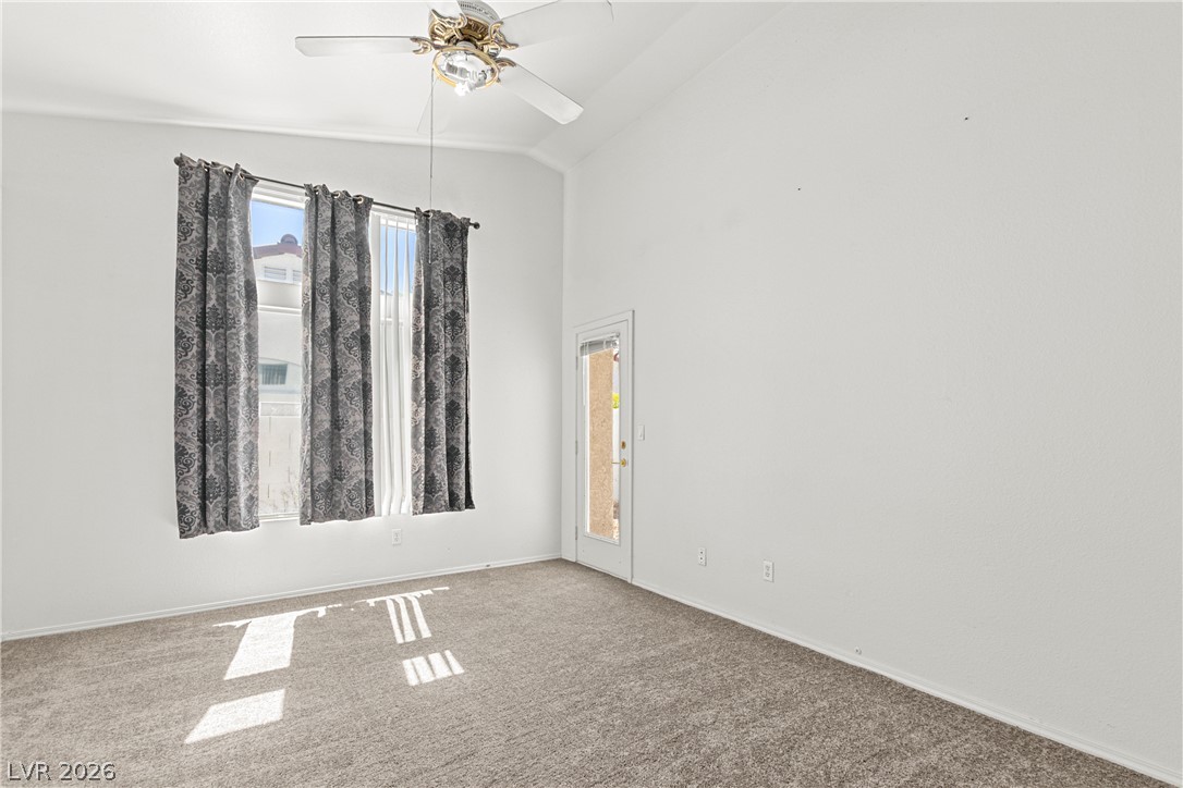 1815 Stablegate Avenue Henderson, NV 89012 - Photo 16 of 28 A quiet bedroom with vaulted ceilings and a glass-paneled door opening to outdoor tranquility.