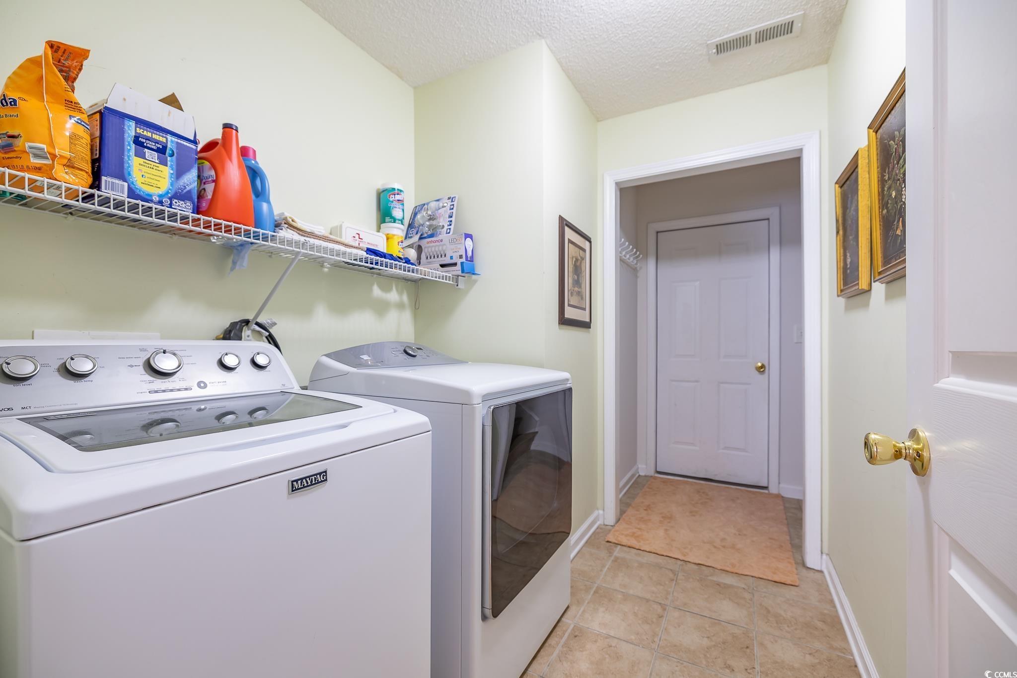 5077 Capulet Circle Myrtle Beach, SC 29588 - Photo 14 of 27 Laundry room with washer and dryer, a textured ceiling, and light tile patterned floors