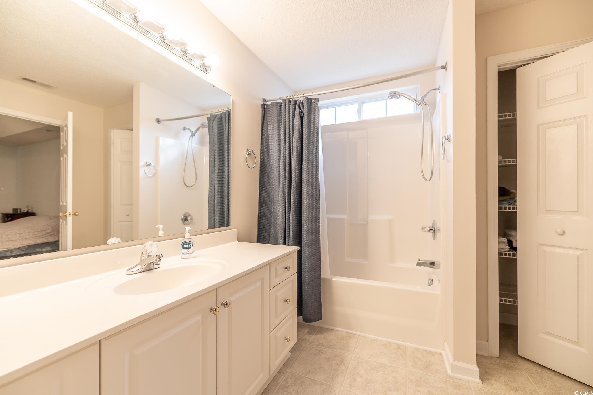 5077 Capulet Circle Myrtle Beach, SC 29588 - Photo 18 of 27 Ensuite bathroom with vanity, shower / bath combination with curtain, and light tile patterned floors