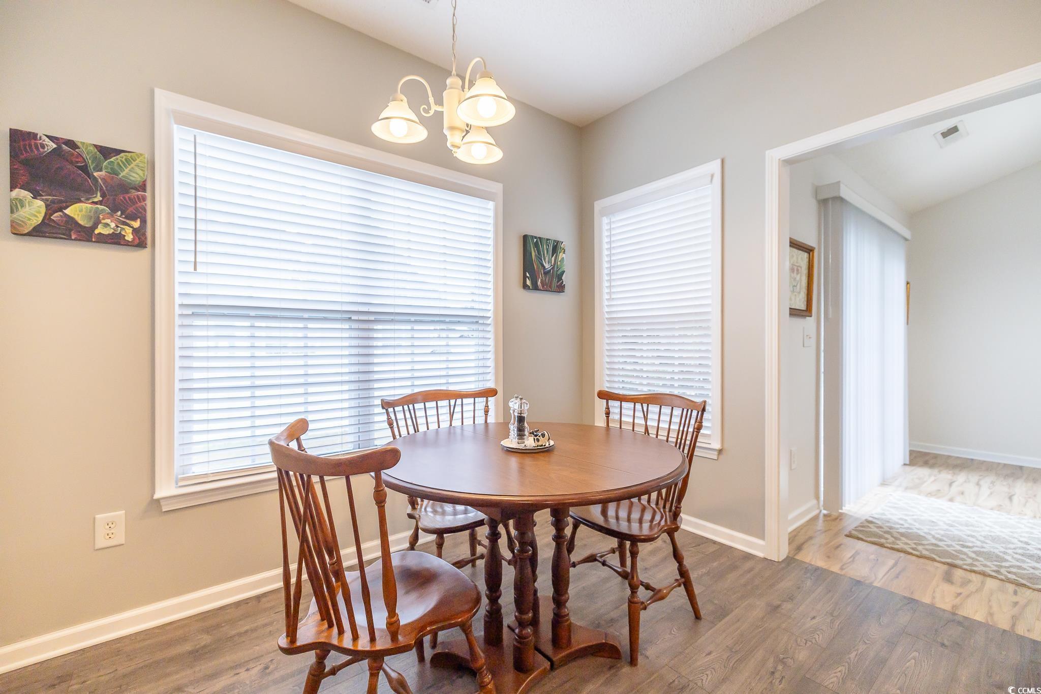 5077 Capulet Circle Myrtle Beach, SC 29588 - Photo 22 of 27 Dining space featuring wood finished floors, a chandelier, and plenty of natural light
