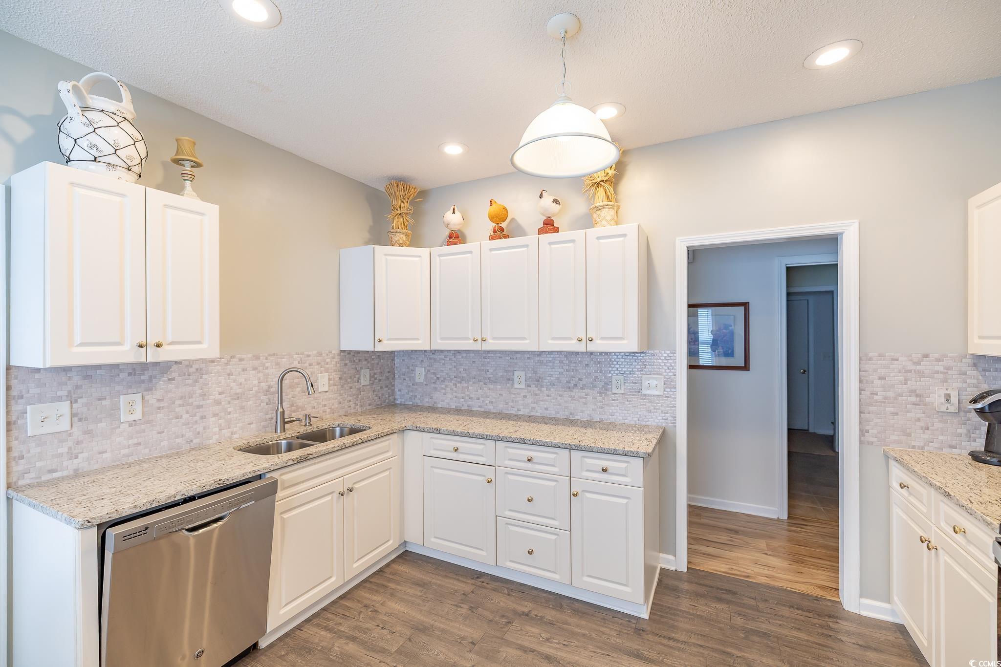 5077 Capulet Circle Myrtle Beach, SC 29588 - Photo 23 of 27 Kitchen featuring dishwasher, light stone countertops, hanging light fixtures, white cabinetry, and a textured ceiling