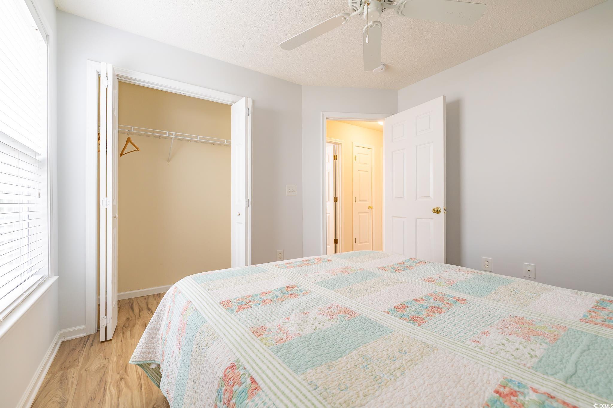 5077 Capulet Circle Myrtle Beach, SC 29588 - Photo 26 of 27 Bedroom featuring ceiling fan, a closet, wood finished floors, and a textured ceiling