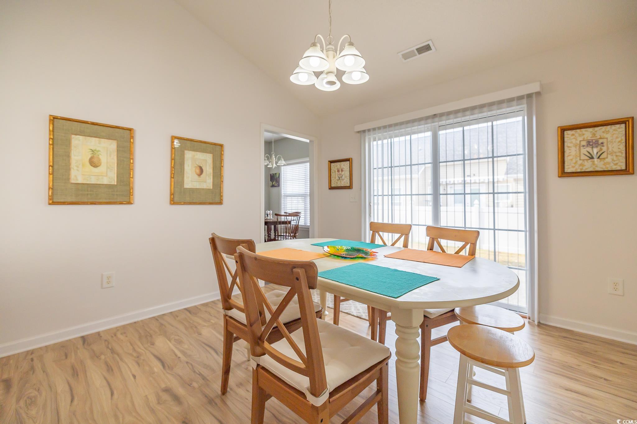 5077 Capulet Circle Myrtle Beach, SC 29588 - Photo 6 of 27 Dining space featuring vaulted ceiling, light wood finished floors, and a chandelier
